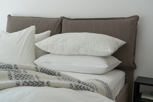 A neatly made bed with fluffy pillows and cozy blankets arranged on top.